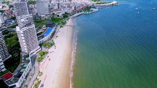 海滨城市高楼边的沙滩和海水景象