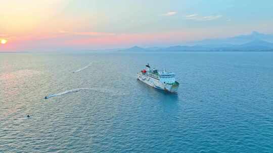 海南三亚橘红色夕阳晚霞行驶的巨型豪华游艇视频素材模板下载