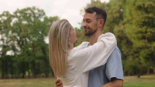 快乐的夫妇在公园里旋转享受家庭生活