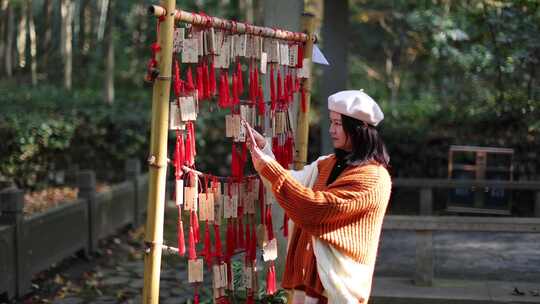 年轻女子新春祈愿纳福挂许愿牌