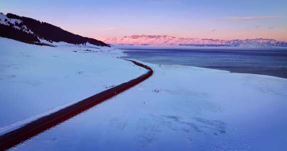 航拍冬季赛里木湖粉色天空雪山日出