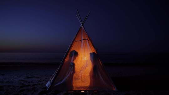 露营二人情侣海边帐篷暖光向海边走夜晚大海视频素材模板下载