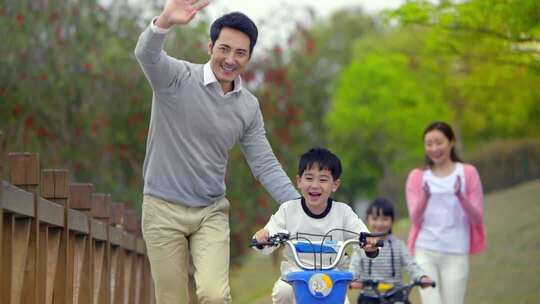 一家人湖边栈道骑自行车游玩