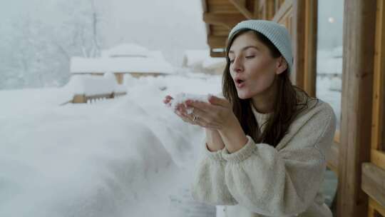 女人吹掉手上的雪