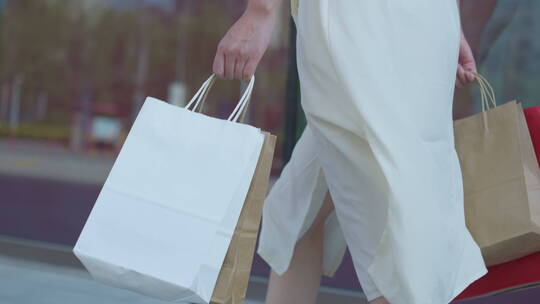 中国女性在商场购物手拎购物袋步行