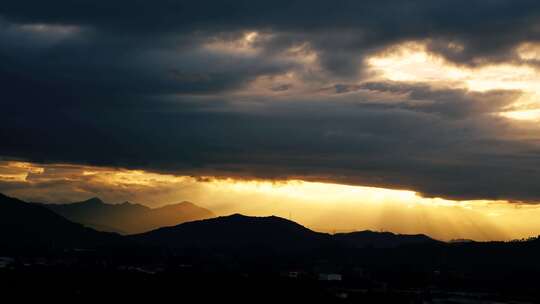 山峦之上夕阳穿透云层景观