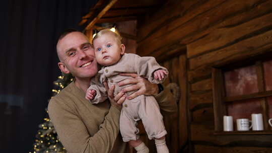 爸爸手里抱着一个小婴儿。父亲和婴儿儿子在