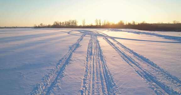雪地摩托的足迹和日落