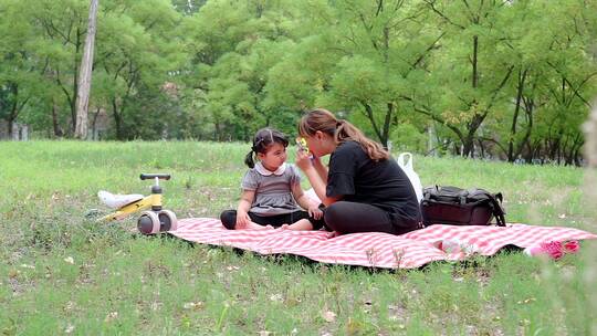 在公园草坪上玩耍的中国母女