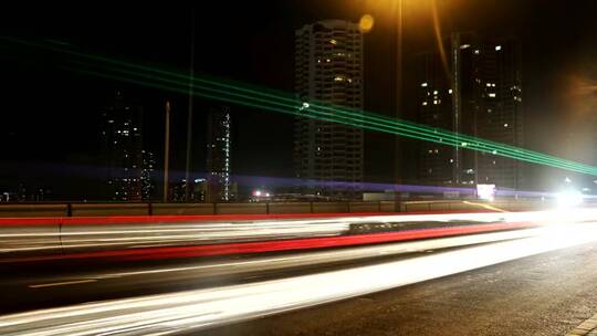 夜间的高速公路上有汽车和建筑物