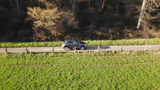 一辆汽车沿着乡村道路行驶的无人机镜头