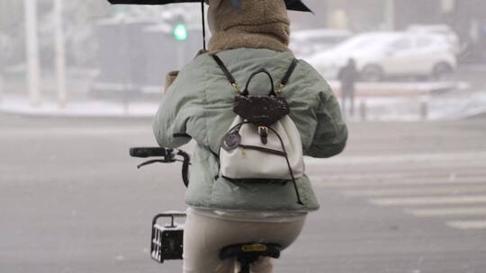 下雪天骑自行车的女孩背影