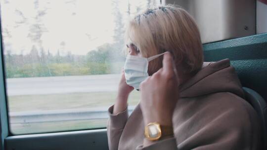 年轻人在公交车上戴上口罩