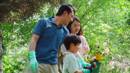 幸福的一家三口在院子里浇水视频素材模板下载