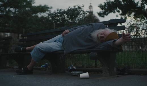 街道长椅上睡觉的老人