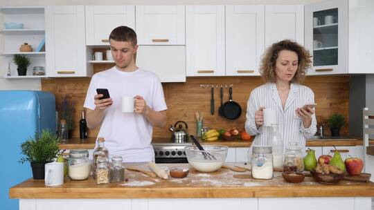 年轻夫妇在厨房使用手机视频素材模板下载