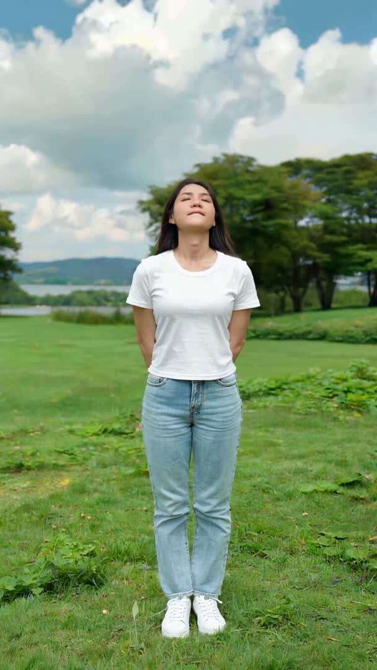 女子户外草地闭眼深呼吸