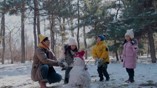 快乐家庭在雪地里堆雪人