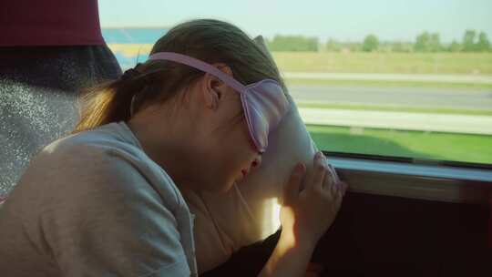 戴着睡眠面罩的女孩在运输车辆中休息，在旅