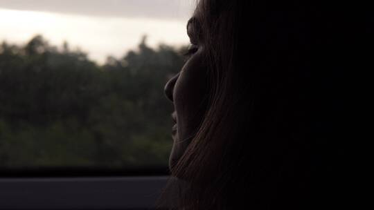 女乘客透过车窗看窗外风景