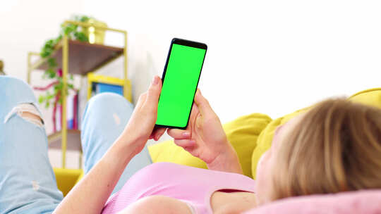 粉色上衣金发女郎手中拿着带绿屏色度键的手机视频素材模板下载