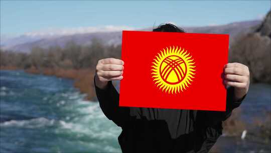 手持吉尔吉斯斯坦国旗旗帜的人