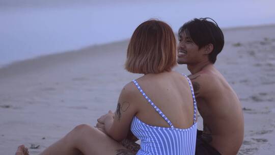 情侣在海滩边聊天
