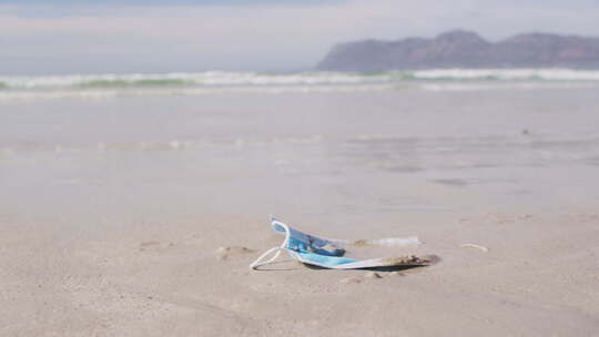 一个面罩躺在沙滩上的沙滩上，背景是波浪