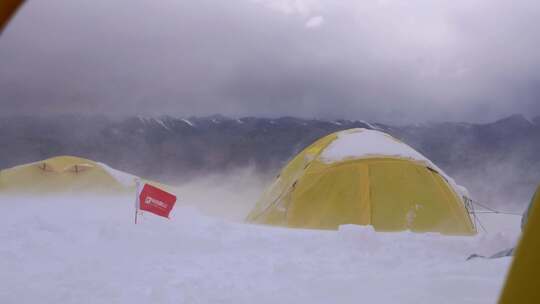 大风中的新疆慕士塔格峰雪山的登山者C1营地