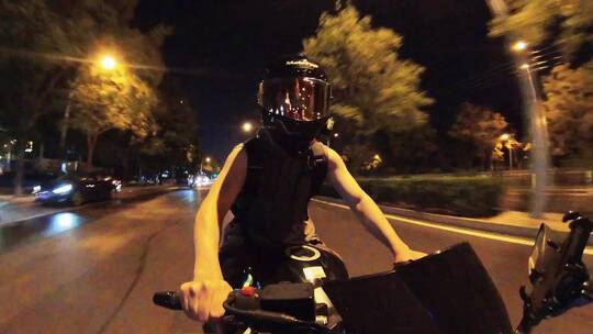 夏季夜晚男子骑摩托车穿梭在城市街道上