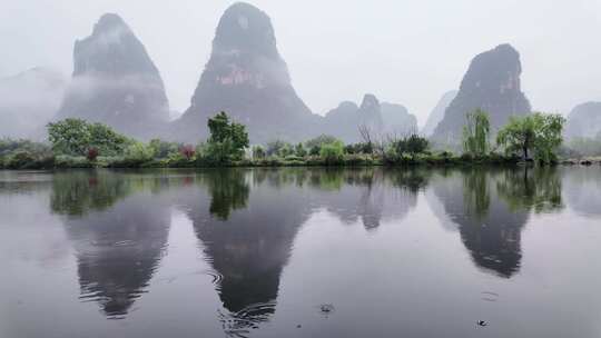 雨天湖景倒映绿树青山的宁静画面