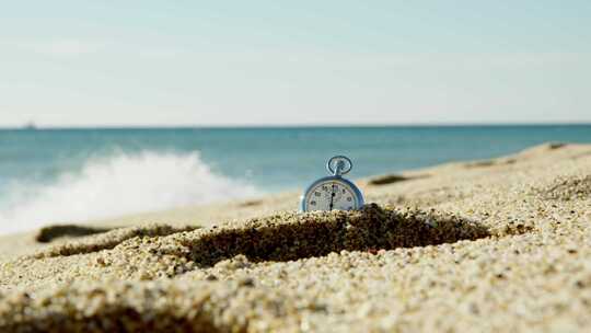 老式秒表埋在沙子里的沙滩上