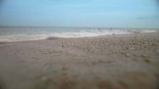 海浪冲过沙滩，进入相机镜头，慢动作