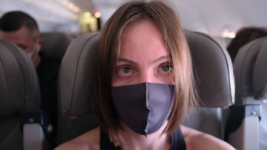 飞机上的戴口罩的女人