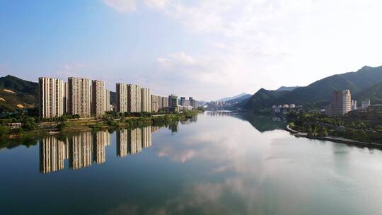 倒映着蓝天白云的新安江和建德河边现代建筑