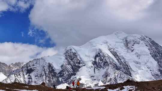 航拍垭口观看贡嘎山区雪山群峰的徒步旅行者