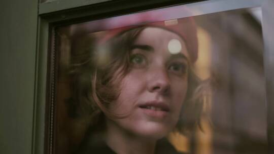 戴贝雷帽的女模看着窗外视频素材模板下载