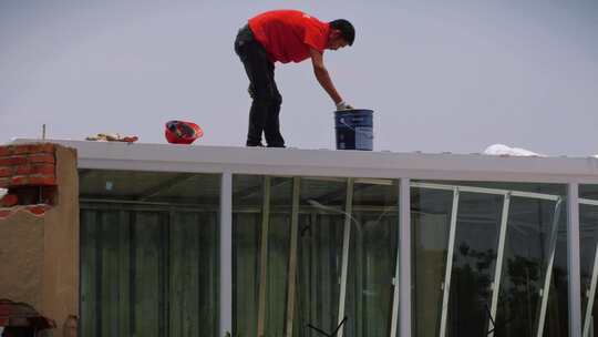 油漆工人烈日粉刷屋顶视频素材模板下载