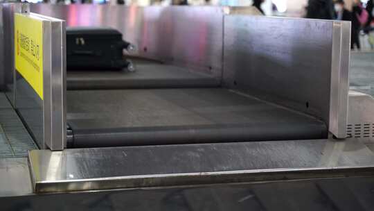 机场行李提取区转盘上移动的行李箱旅行包