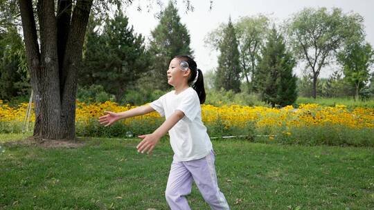 夏季在公园草坪上奔跑的东方女孩