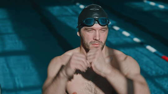 肌肉发达的高加索男性游泳运动员热身后戴上视频素材模板下载