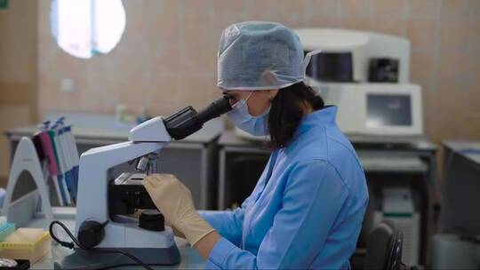 穿着蓝色实验室外套的女性医学助理在实验室
