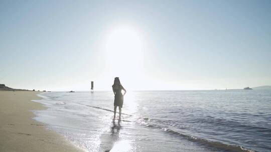 阳光下美女跑向海边玩耍踢海水欢快女孩少女