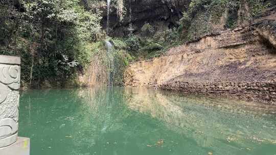 水边崖壁绿植环绕的自然景观