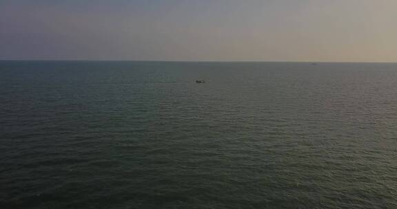 海上伴随着晚霞孤独的归家渔船