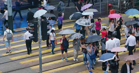 人们在雨天穿过城市的街道