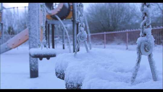 操场上白雪覆盖的秋千