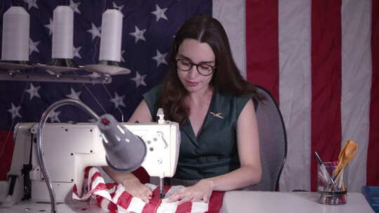 女人用缝纫机做美国国旗
