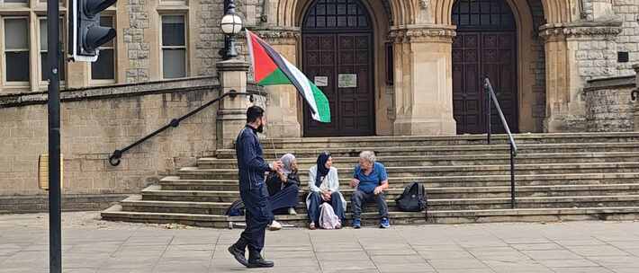 英国伦敦伊林市政厅前，人们在谈论和挥舞巴