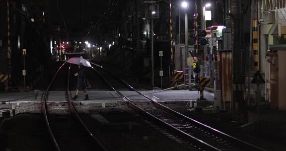 大伞穿过铁路的女人